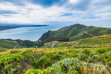 View from Marin Headlands overlooking winding coastal roads, rolling green hills, and the Pacific...