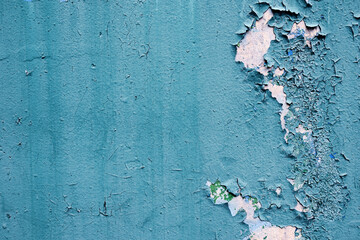 Abstract background. Texture of old turquoise wall with peeling, cracked paint.