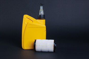 Motor oil in plastic canister and filter on dark grey background, space for text