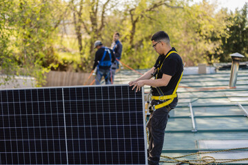 Workers installing solar panel on a roof on a sunny day