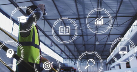 Using tablet worker wearing safety vest by railing monitoring data icons in warehouse, copy space