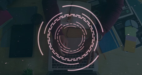 Circular digital interface image over person typing on laptop at desk