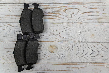 Disc brake shoes on a white wooden background. Top view