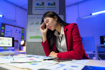 Stressed businesswoman suffering from headache while working with financial reports in office at...