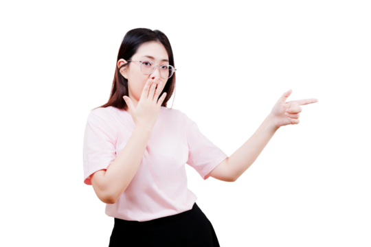 A young woman with glasses wears a pale pink shirt and black pants, covering her mouth with one hand and pointing with the other. - Powered by Adobe