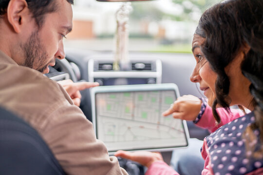 Couple traveling using gps map on tablet in car