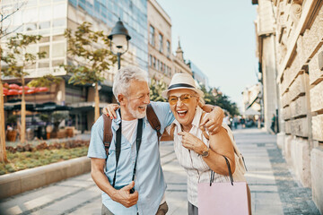 Happy senior couple sightseeing and laughing together in the city
