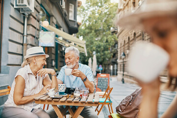Senior couple enjoying coffee together at outdoor cafe in the city