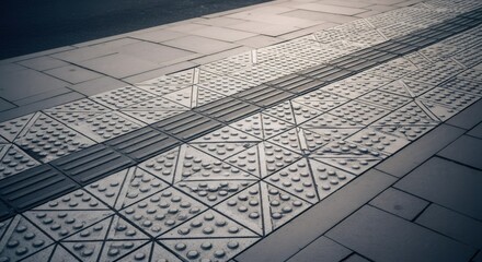 Tactile paving strip with raised dots and lines for visually impaired people on a city sidewalk. Accessibility surface.