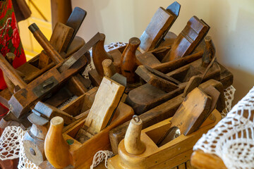 collection of old wooden hand planes arranged in a basket, with a rustic interior in the...