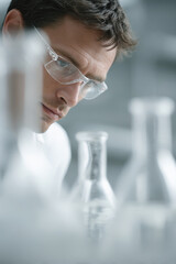 focused chemistanalyst examining chemical reagents positioned on right side of frame