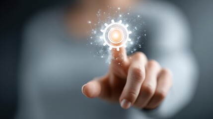 A person is reaching out to touch a glowing gear icon that represents technology and innovation. The background is blurred, focusing on the digital interaction.