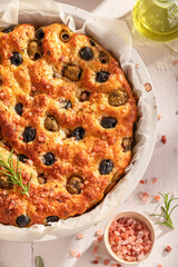 Hot focaccia with green herbs and olives.