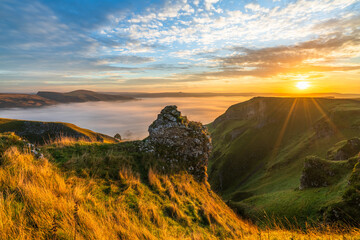 Winnats Pass at sunrise with cloud investion sunflare in the valley over Castleton. Peak District. England