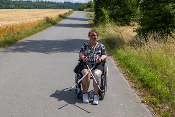 Positive attitude: Woman with walking sticks and wheelchair