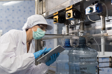 Drinking water manufacturers. Water filling machine. 20 Liter bottled on conveyor during filling...