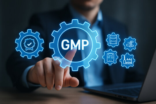 Man pointing at gmp gear icon with laptop and icons representing manufacturing processes in the background