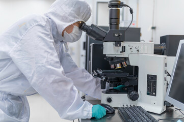 Scientist in laboratory,research experiment using microscope,lab work and sample analysis,scientific research process.