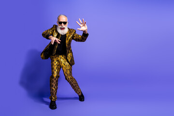 Eccentric elderly man in a stylish patterned suit striking a dramatic pose against a vibrant purple background