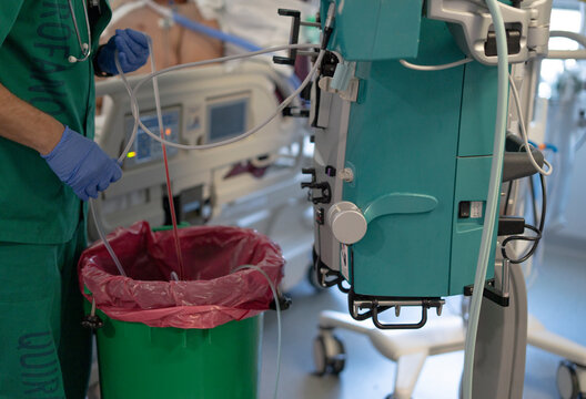Surgeon disposing medical waste after surgery using dialysis machine in hospital room