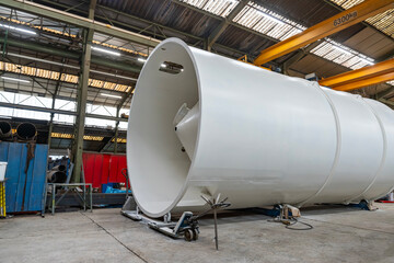Plan large d’une pièce industrielle au cœur d’un atelier, montrant son environnement de travail, les machines et les installations techniques autour.