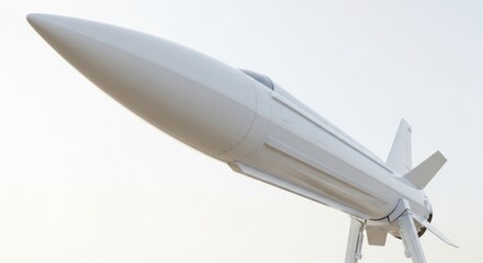 Obraz premium A white, futuristic hypersonic missile or experimental aircraft with a sharp, pointed nose, presented against a bright, clear sky, symbolizing innovation and speed in aerospace.
