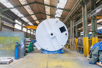 Plan large d’une pièce industrielle au cœur d’un atelier, montrant son environnement de travail, les machines et les installations techniques autour.