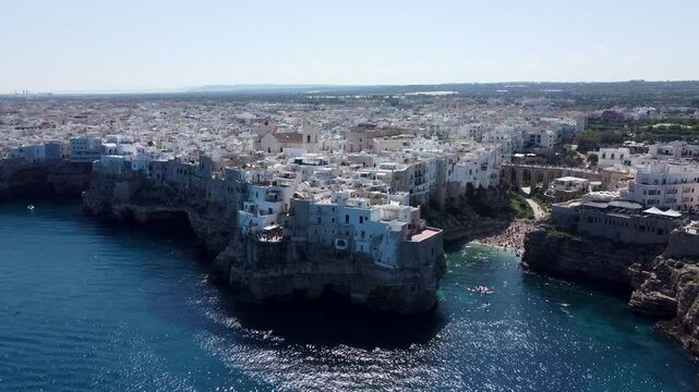 Drone footage of Polignano a Mare, Italy &ndash; featuring Lama Monachile beach, turquoise sea, dramatic cliffs, and scenic views of the Adriatic coastline in Puglia.