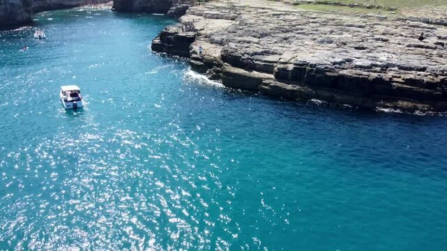 Drone footage of Polignano a Mare, Italy &ndash; featuring Lama Monachile beach, turquoise sea, dramatic cliffs, and scenic views of the Adriatic coastline in Puglia.