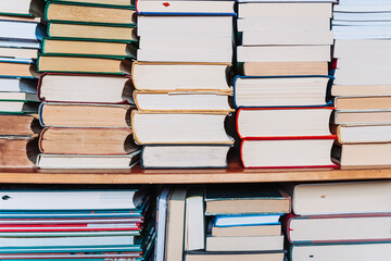 Stacks of old books arranged with page edges facing the camera. Neutral background, vintage feel,...