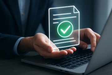 Person holding glowing document with checkmark above laptop in a business setting at a desk