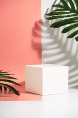 Cosmetics product advertising stand. Exhibition white podium with geometric shapes on a pink background with palm leaves and shadows. Empty pedestal to display product packaging. Mockup