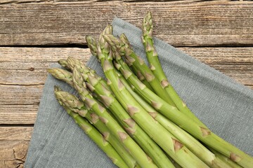 Fresh raw asparagus spears on wooden table, top view