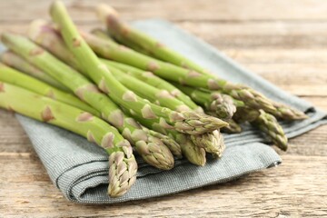 Fresh raw asparagus spears on wooden table, closeup