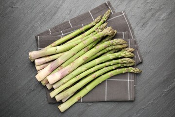 Fresh raw asparagus spears on black table, top view