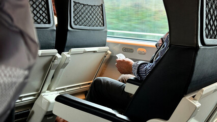 Seated solitude on a train, Caucasian male engrossed in digital daydreams, pondering Festivus and...