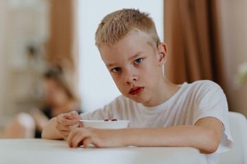 A boy with hearing aids enjoys a healthy breakfast, showcasing inclusive daily routines and...