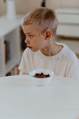 A boy with hearing aids enjoys a healthy breakfast, showcasing inclusive daily routines and...