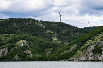 Wind turbines spin atop verdant hills, whispering secrets of Midsummer's Day and Eco-Conscious...