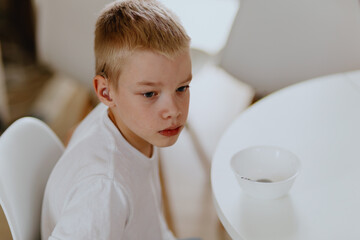 A boy with hearing aids enjoys a healthy breakfast, showcasing inclusive daily routines and...
