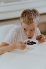 A boy with hearing aids enjoys a healthy breakfast, showcasing inclusive daily routines and...