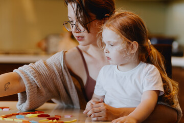 A sweet 3-year-old girl plays board games with her mom, sharing precious moments of love, learning and bonding. Perfect for family and early education content