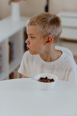 A boy with hearing aids enjoys a healthy breakfast, showcasing inclusive daily routines and...