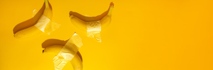 Surreal bananas defy gravity on vivid yellow, wrapped in artful tape, celebrating quirky creativity...