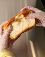 Gloved hands gently pull apart a freshly baked brioche, echoing the comforting whispers of Hygge...