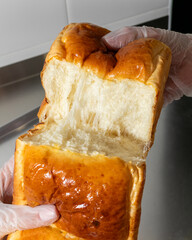 Fluffy bread tear revealing gooey interior, invoking tactile delight, reminiscent of Japanese Shokupan breakfast rituals, comforting carb fest