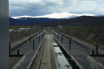 Train tracks and the snow-capped mountains of Sierra de Guadarrama in the background
