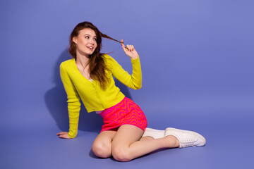 Stylish young woman in vibrant outfit posing against pastel purple backdrop for fashion and lifestyle themes