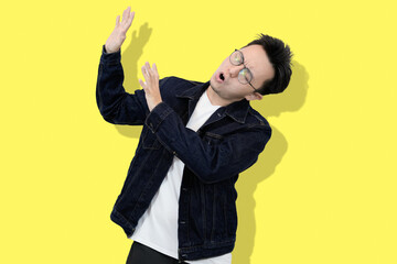 young asian man refusing or no pose in yellow isolated background