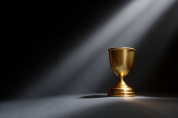 Golden trophy standing on a podium with dramatic spotlight, symbol of success and achievement